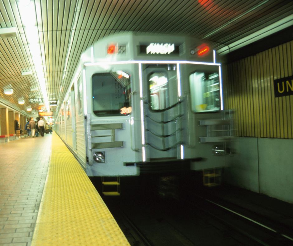 地下鉄のホームに滑り込んでくる電車の画像。