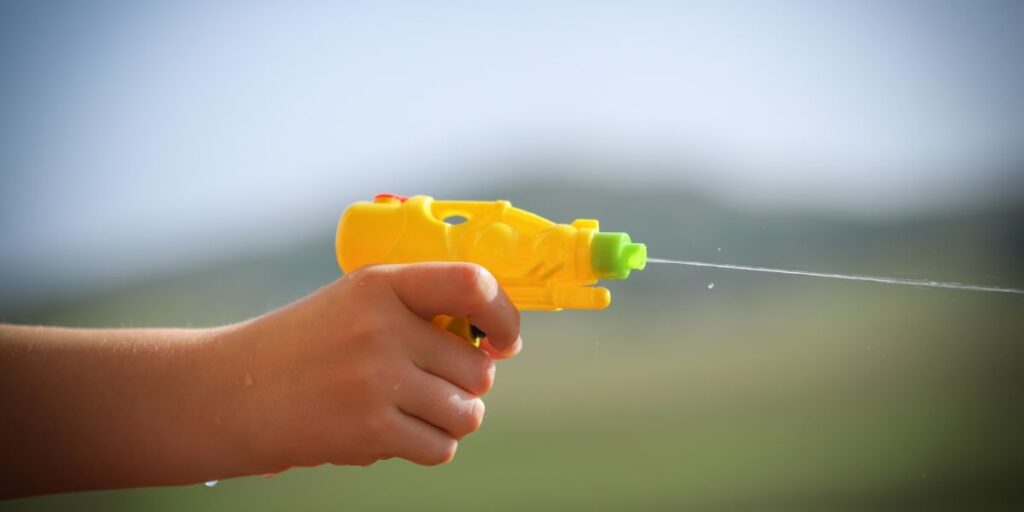 water gunを撃つ子供の手の画像。