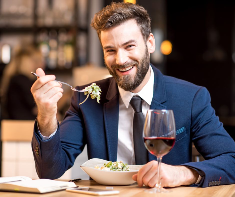 A man laughing and eating a sumptuous meal