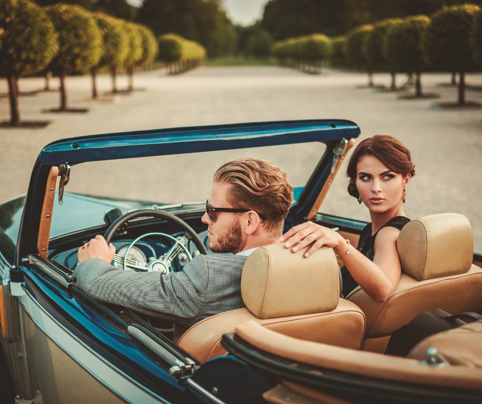 young man riding a classic car